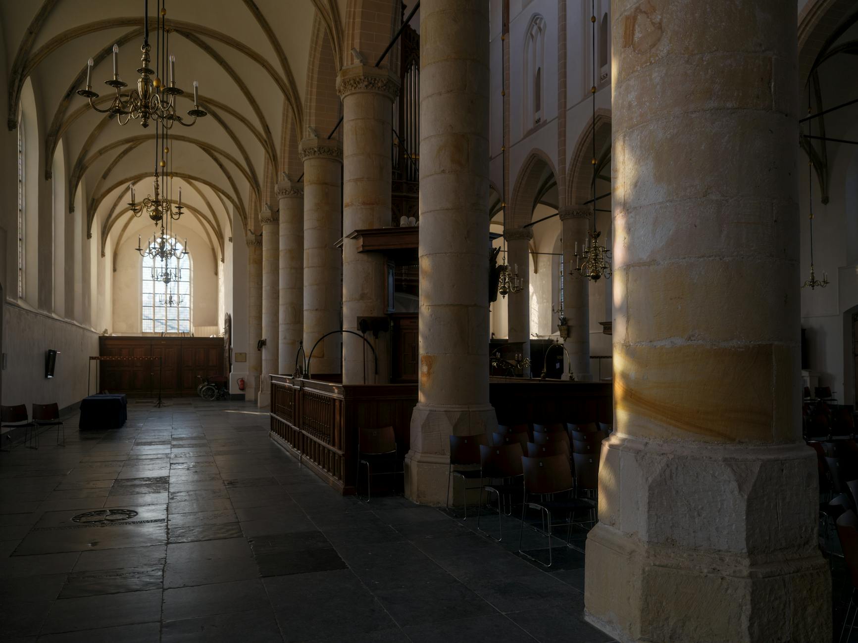 Cathedrals of Shadow and Light The Enduring Spell of Gothic Awe 1 - Grand Boudoir Interior view of a gothic church with stone columns, arches, and sunlight streaming through a large window.