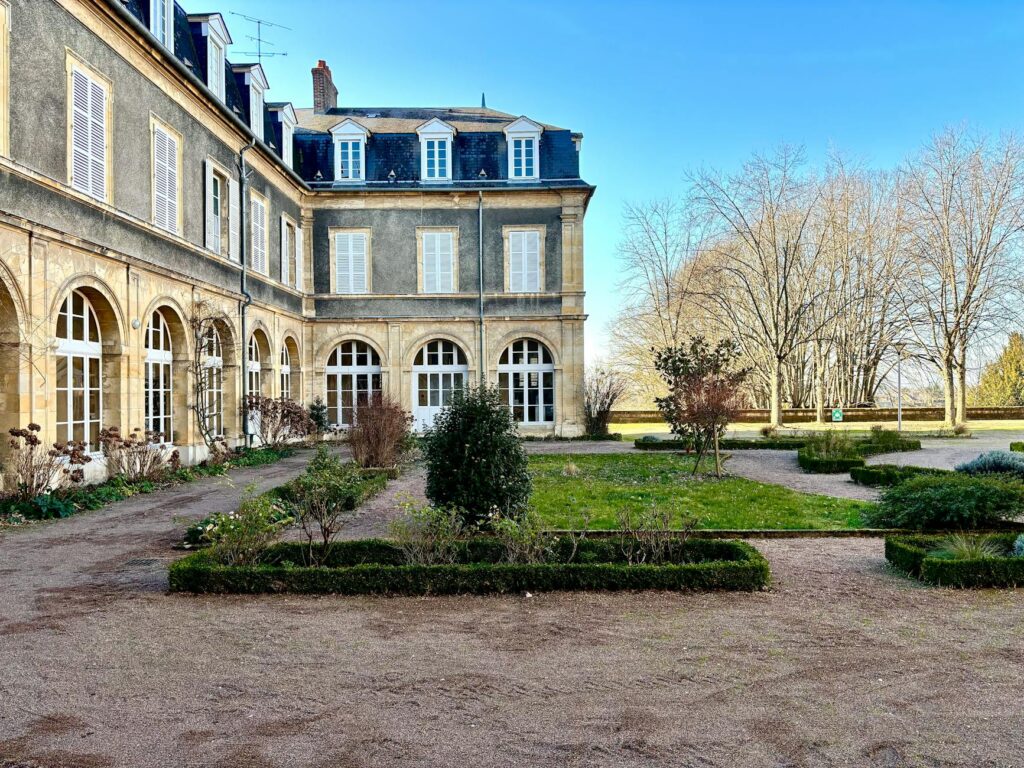 French Aristocracy - Grand Boudoir Beautiful European mansion with classic architecture and landscaped garden in daylight.