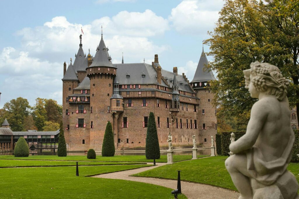 French Aristocracy 4 - Grand Boudoir De Haar Castle with garden view and historic architecture in a vibrant setting.