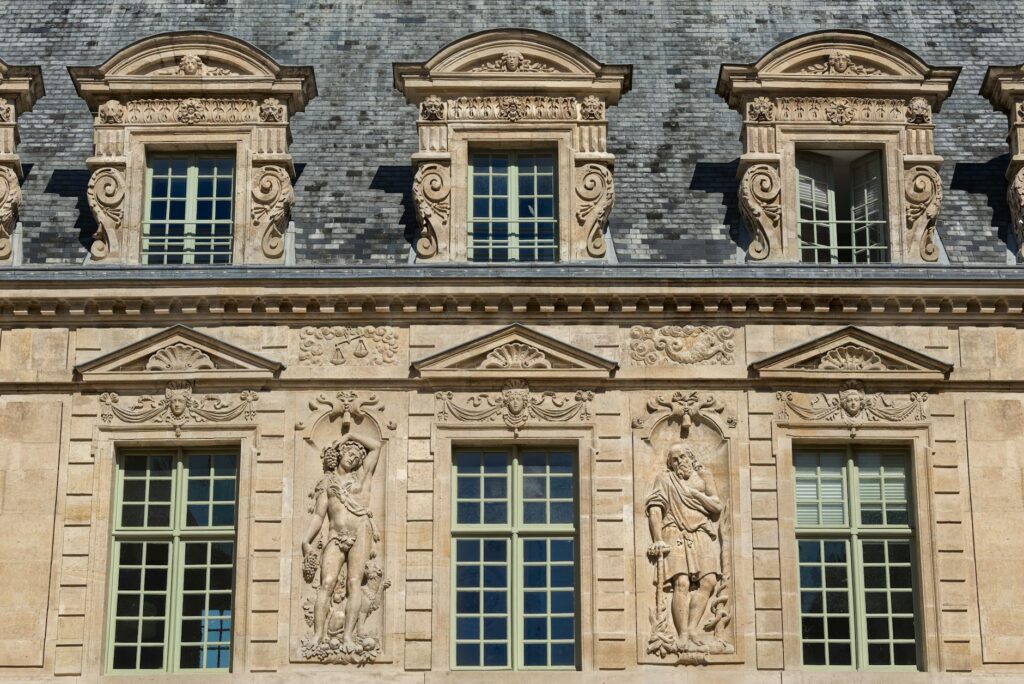 French Aristocracy 6 - Grand Boudoir Detailed stone sculptures and windows on a Parisian building facade.