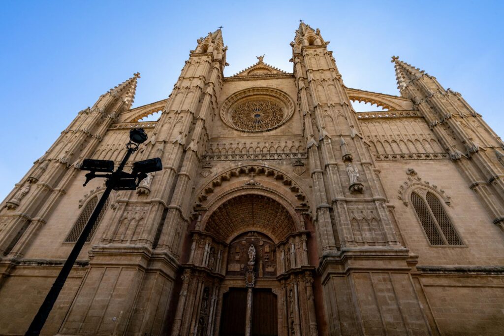 Gothic Cathedrals - Grand Boudoir Stunning view of La Seu Cathedral, a Gothic masterpiece in Palma, Mallorca, under a clear blue sky.