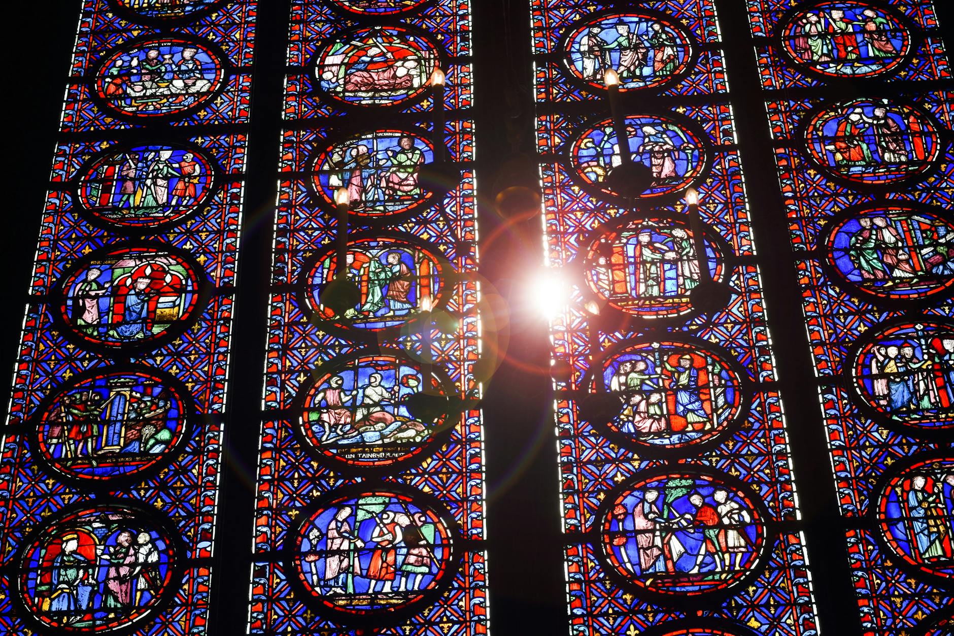 The Hidden Psychology of Gothic Cathedrals - Grand Boudoir Sunlight streaming through colorful stained glass windows in a cathedral, highlighting intricate designs.