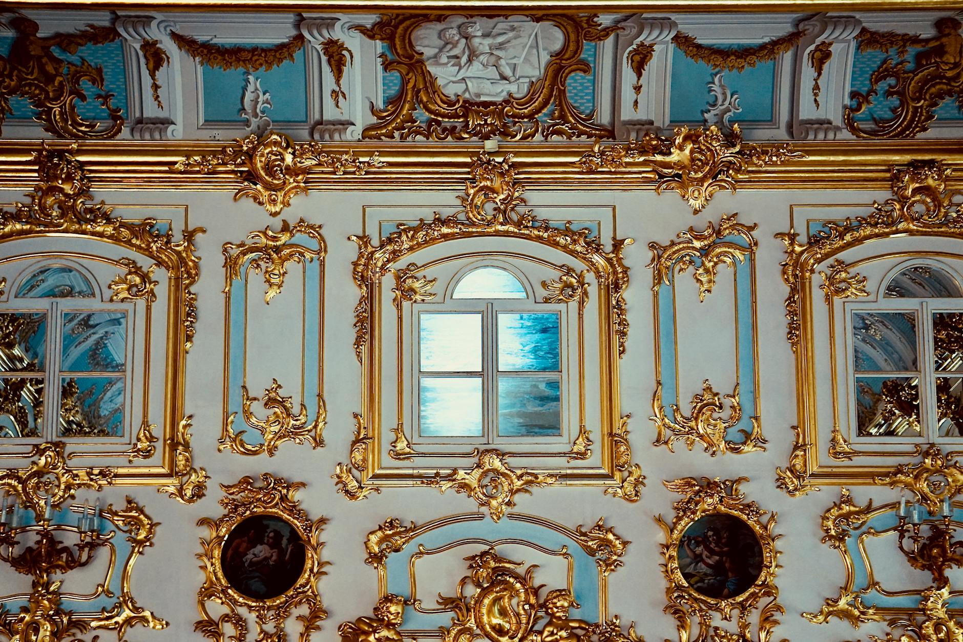 Luxurious gold-trimmed renaissance architecture with ornate windows in a museum setting.