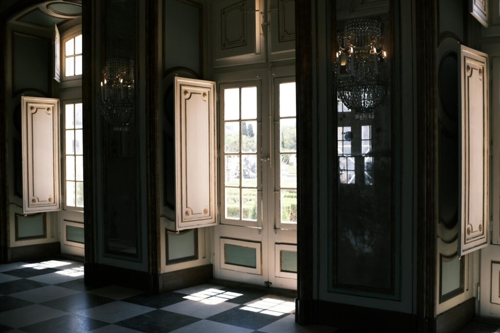 rococo room 1 - Grand Boudoir A luxurious palace room in Queluz, Lisbon with elegant windows and chandeliers.