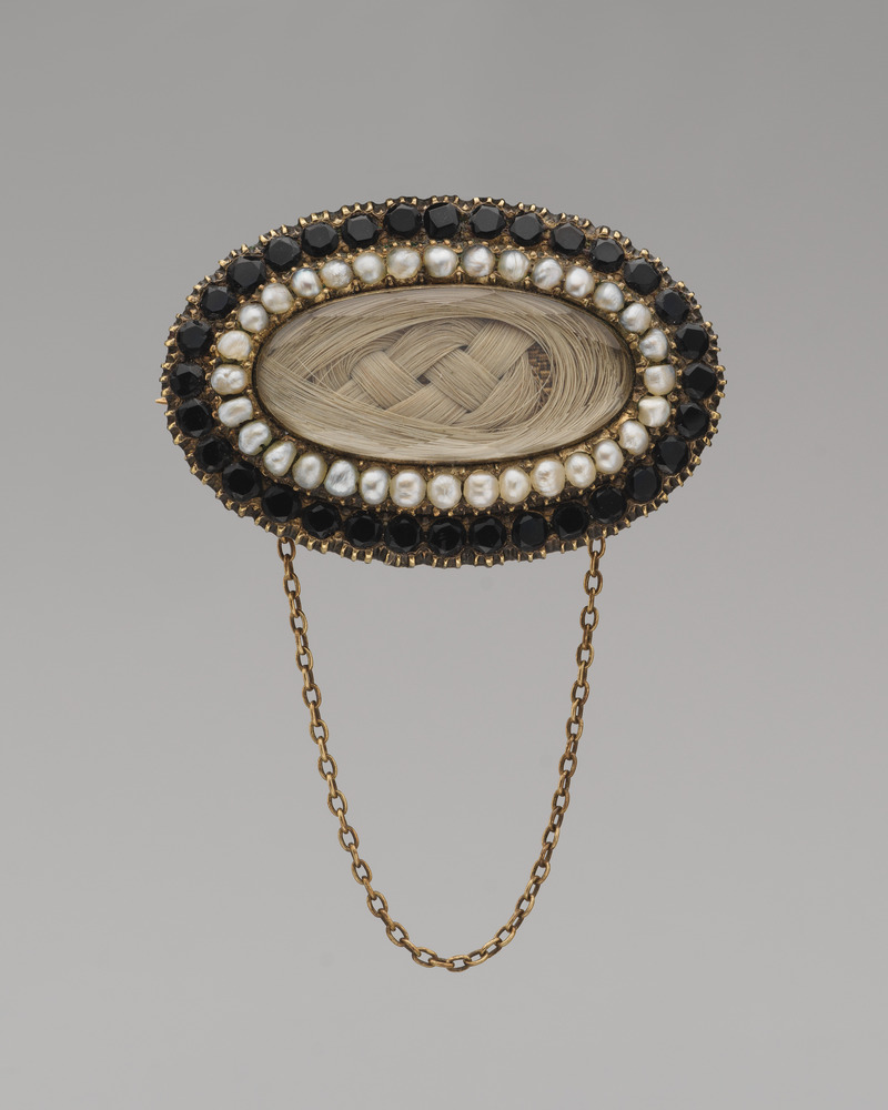DP 42517 0011 - Grand Boudoir Discover the secrets behind Victorian mourning brooches—tiny relics of grief, love, and hidden messages worn close to the heart.
