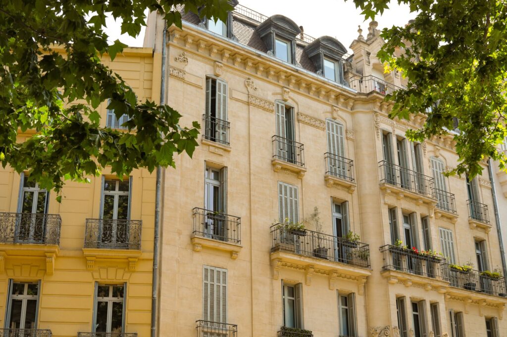 pexels photo 32553295 - Grand Boudoir Elegant French-style architecture featuring balconies and detailed stonework under tree shade.